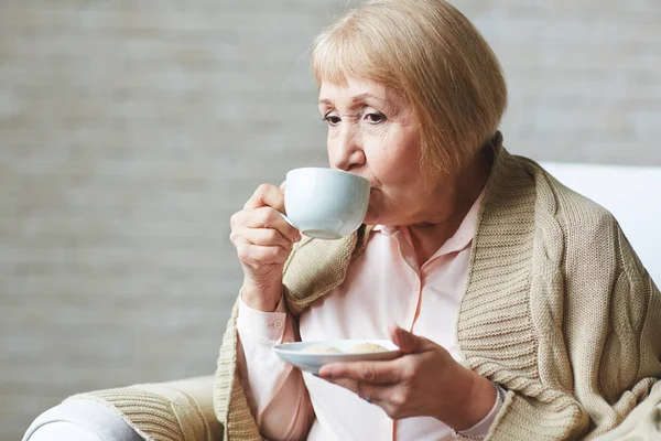 Пожилая женщина с чашкой кофе — стоковое фото