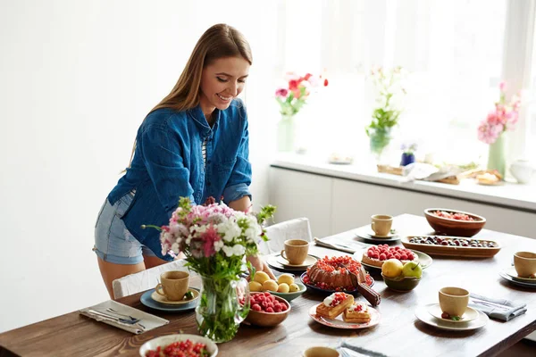 Donna apparecchiare la tavola con dolci — Foto Stock