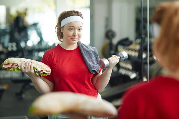 Woman doing weight exercises with sandwich — Stock Photo, Image