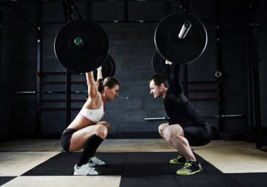 adam ve büyük barbell tutan kadın