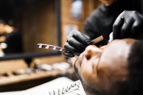 Friseur rasiert Gesicht des Kunden — Stockfoto