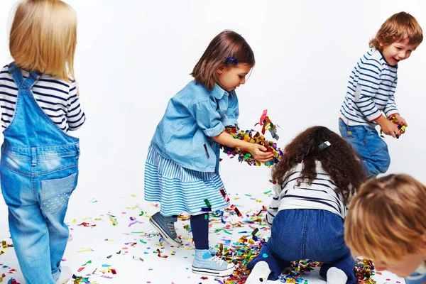 Glückliche Kinder, die mit Konfetti spielen — Stockfoto