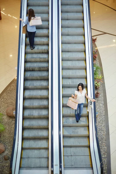 Compradores moviéndose en escaleras mecánicas — Foto de Stock