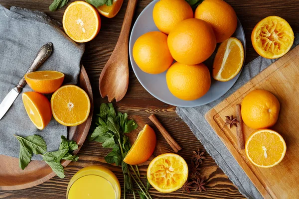 Ripe oranges cut in half, mint, cinnamon — Stock Photo, Image