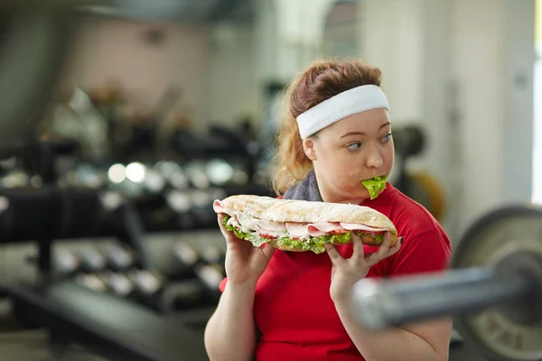 Žena jíst velké mastné sendvič — Stock fotografie