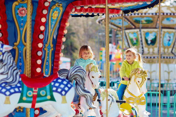 girls riding on merry-go-round