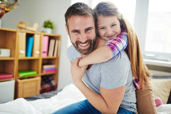 Härlig familj sitter på sängen — Stockfoto