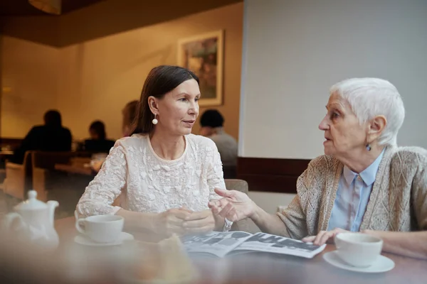 Females looking through magazine — Stock Photo, Image