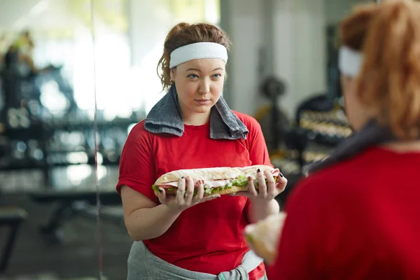 Kvinna med smörgås medan du arbetar — Stockfoto