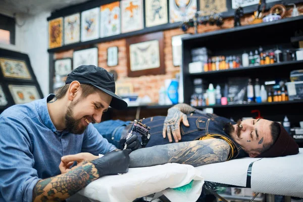 Tattooer 在处理客户端的球帽 — 图库照片