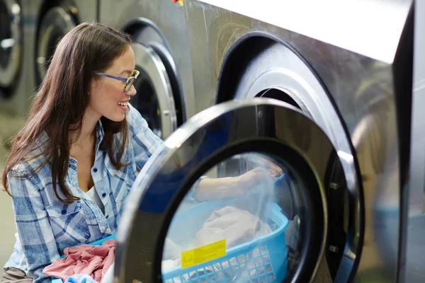 Girl putting clothes into tumble — Stock Photo, Image