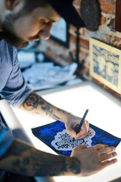 Мужчина вытаскивает фотографию татуировки — стоковое фото