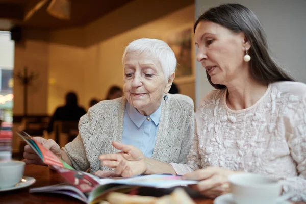 Mulheres idosas discutindo artigo — Fotografia de Stock
