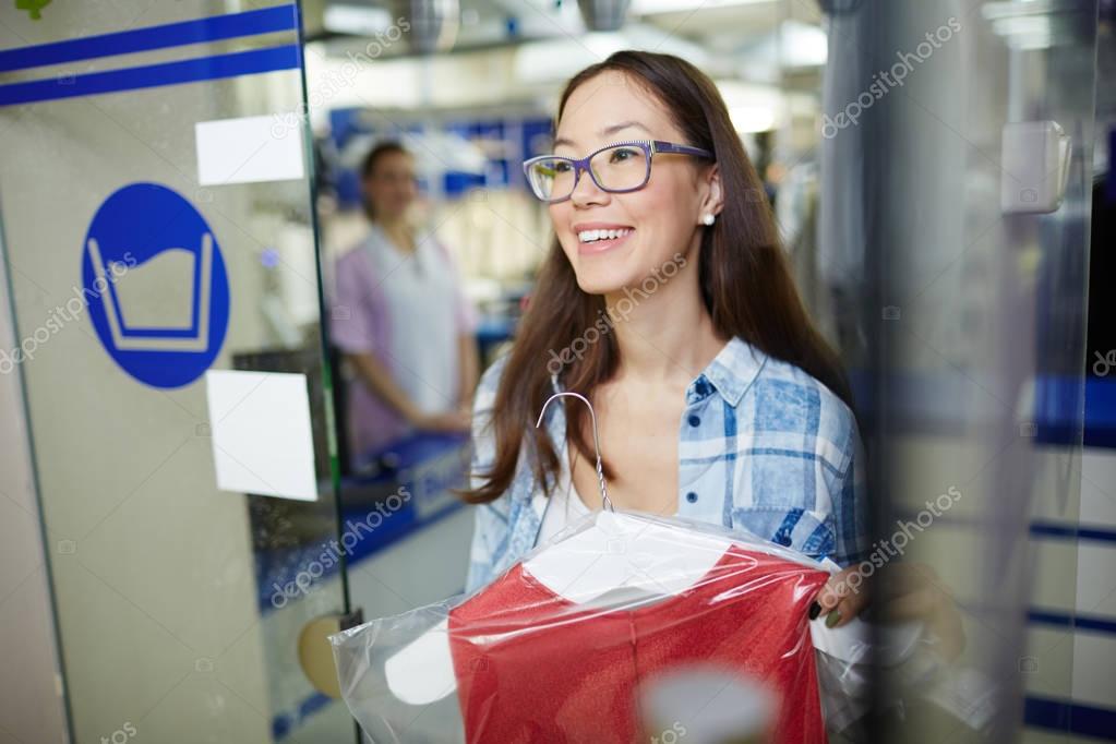 Adolescent female carrying her clothes to laundromat or dry cleaning service