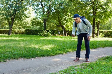 Yolda yürürken ve popüler mobil oyun, tam uzunluk portre oynayan genç adam konsantre