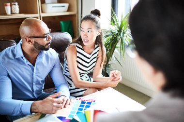 Modern açık plan ofiste bir araya süre yetenekli iç tasarımcı tartışarak yeni fikirler çok etnik gruptan oluşan grup