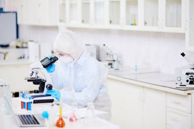 Mikroskop mutasyon virüs modern laboratuvar eğitimi alırken arıyorum hazmat uygun giyen kadın mikrobiyolog profil görünümü