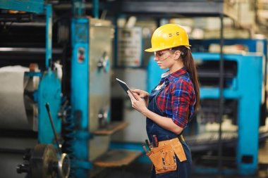 Kot modern bitki üretim bölümünde dijital tablet üzerinde çalışan genel konsantre genç işçi profil görünümü