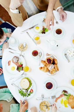 Görünümü sunulan tablo ve çevresindeki insanların elleri yukarıda