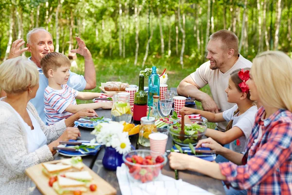 自然環境のテーブルによって収集された幸せな家族 — ストック写真