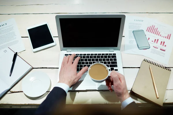 コーヒーを飲みながら ノート パソコンで入力の実業家 — ストック写真