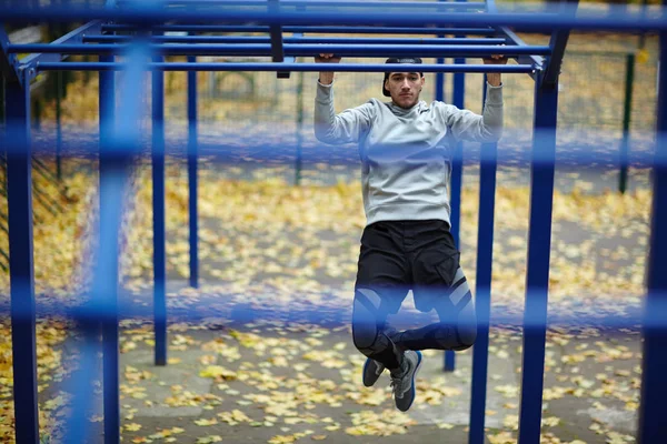 Geconcentreerd Atleet Doen Van Oefeningen Horizontale Balk Met Benen Gekruist — Stockfoto