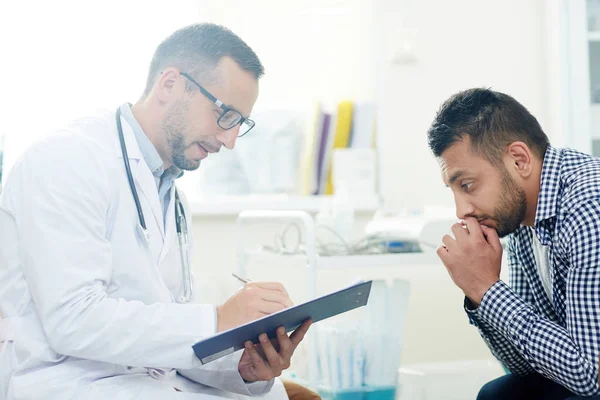 Paciente Pensativo Sentado Frente Médico Llenando Formulario Médico — Foto de Stock