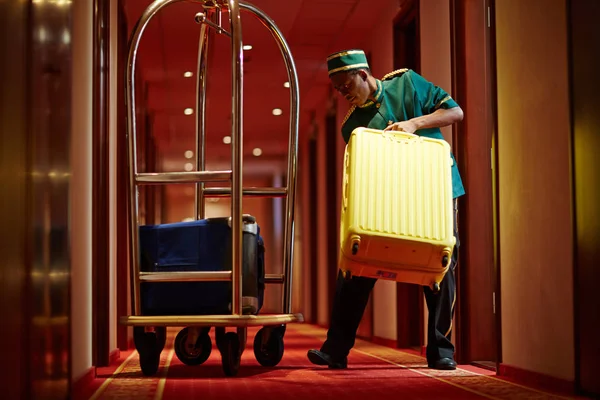 酒店服务员从酒店房间拿出行李箱 — 图库照片