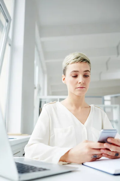 Donna Seria Con Smartphone Messaggistica Dal Posto Lavoro — Foto Stock