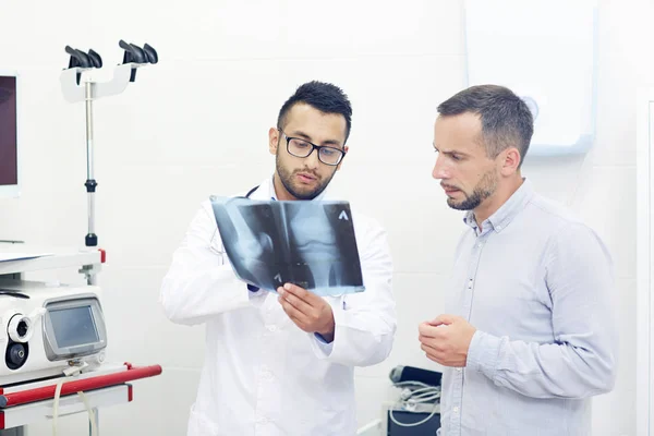 Jovem Clínico Explicando Radiografia Articulação Cotovelo Paciente Durante Visita — Fotografia de Stock