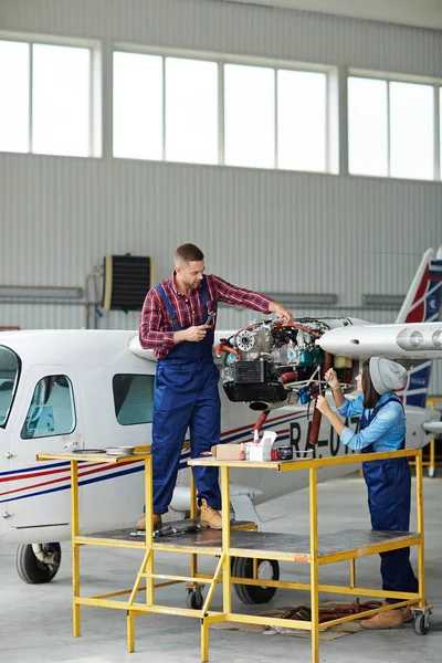 Команда Обслуживанию Самолетов Ремонтирует Самолет Ангаре Два Молодых Механика Мужчина — стоковое фото