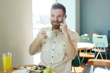 Kafede öğle yemeği ve istemciye telefonda konuşurken genç Ajan