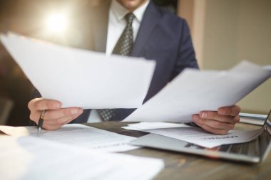 Dizüstü bilgisayar, evrak işleri ile meşgul olan Danışma, sözleşme belgelerinin okuma siyah resmi takım elbise tanınmaz başarılı işadamı portresi portre