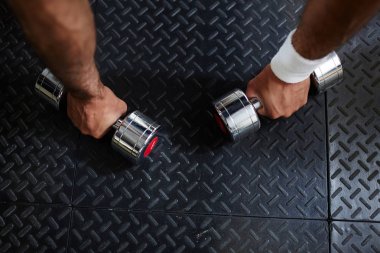 Metalik dumbbells yerden alarak sporcu elleri