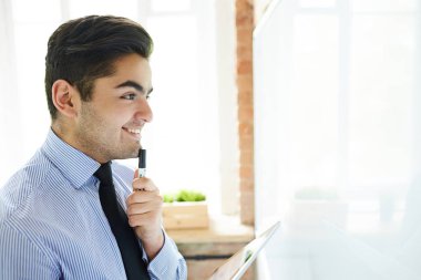 Vurgulayıcı ve beyaz tahta arıyor tablet ile mutlu genç analist