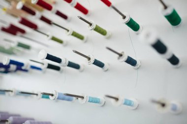 Arka plan resim kompozisyon: renkli dikiş biriktiricileri stand stüdyo, mavi ve yeşil tonları terzilik içinde closeup