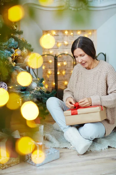 Reife Frau Bindet Rote Schleife Auf Geschenkbox Während Sie Sie — Stockfoto
