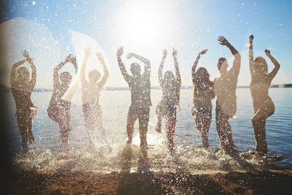 Ряд Друзей Поднимающих Руки Время Брызг Воды Солнечный День — стоковое фото