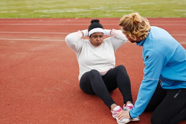 Motivada Jovem Size Mulher Fazendo Sit Ups Estádio Com Ajuda — Fotografia de Stock