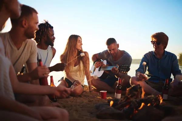 Bir Grup Arkadaş Kamp Ateşinde Gitar Çalan Adamı Dinliyorlar — Stok fotoğraf