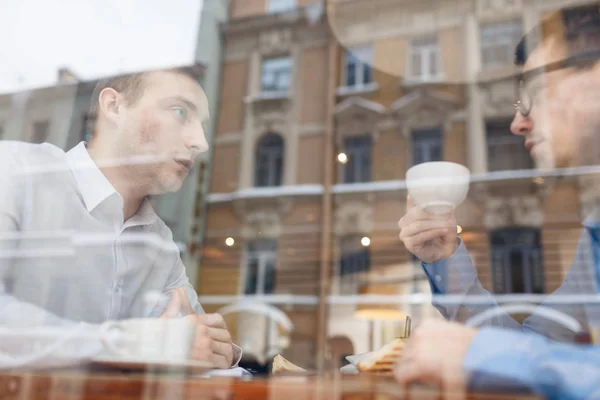 カフェでお茶を飲んで 作業のアイデアを議論する つのビジネス パートナー — ストック写真