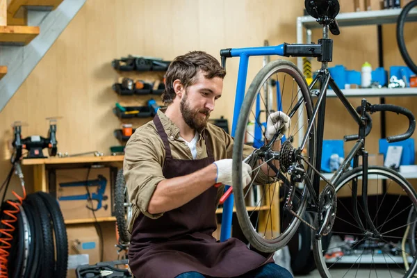 Jonge Meester Werkhandschoenen Schort Repareren Wiel Van Fiets Werkplaats — Stockfoto