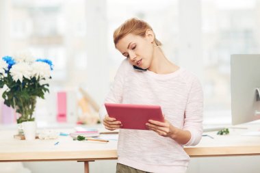 Müvekkili ile arka plan üzerinde dağınık masa geniş studio üzerinden telefon görüşmesi cevap elinde dijital tablet ile meşgul çiçek tasarımcısı