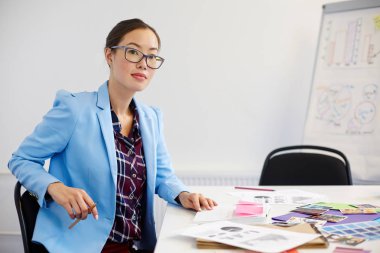 İşyeri tarafından oturan ve yeni proje planı yazma iş kadını