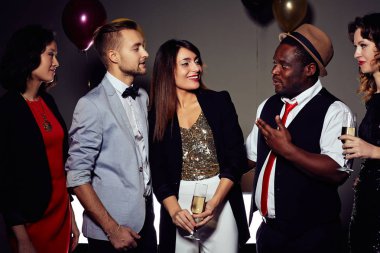 Grup neşeli genç insan gece kulübünde bir araya ve animatedly birbirleri ile sohbet