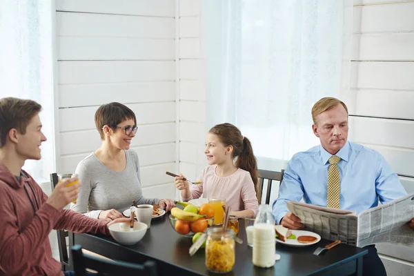 亲密的家庭四享受美味的早餐在家里 他们坐在餐桌上 吃玉米片和聊天 — 图库照片
