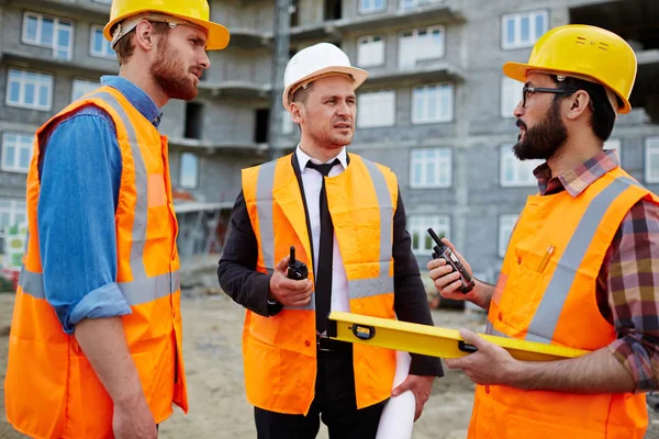 年轻的建设者与 Walkie Talkies 的互动在建筑工地 — 图库照片