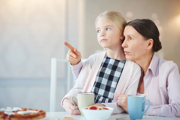 Reife Frau Zeigt Nach Vorne Während Sie Ihrer Enkelin Etwas — Stockfoto