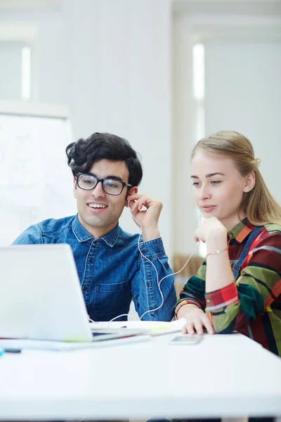 Vänliga Studenter Med Hörlurar Tittar Laptop Skärmen — Stockfoto