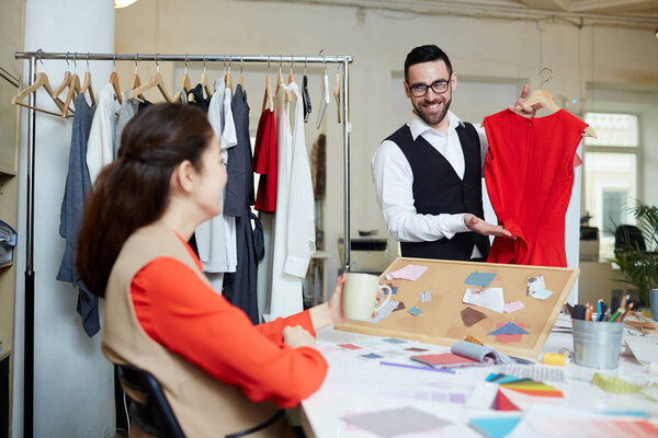 Two fashion designers discussing color and model of new stylish dress